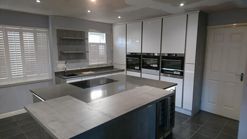 German handless design in Lanarkshire. Concrete effect island and breakfast bar, acrylic ultra gloss tall units, top spec AEG appliances and quartz worktops. Gallery Image