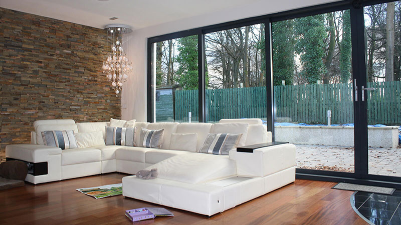 Bifolding doors, feature wall and sofas in open plan living space Gallery Image