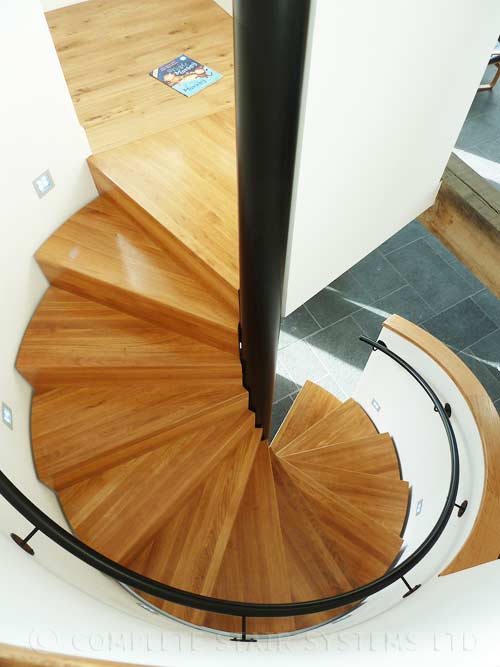 Bespoke Spiral Stair, enclosed balustrade, with boxed oak treads and powder coated steel handrail. Gallery Image